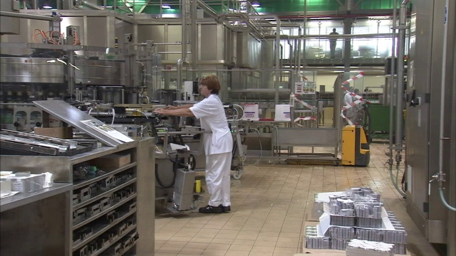 一个工人在啤酒装瓶厂操作机器。视频下载
