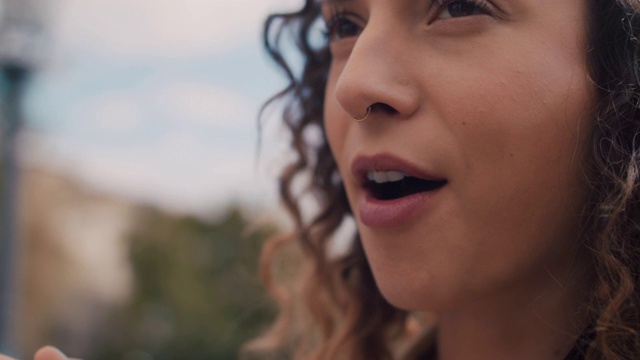 一个穿鼻环的年轻女子坐在柏林的狂欢河边，微笑着吃着蓝莓视频下载