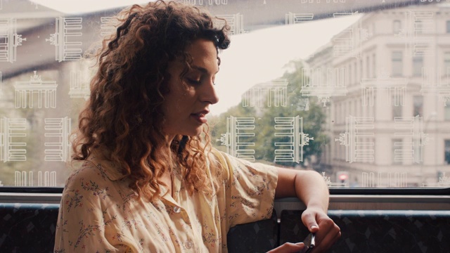一个年轻女子坐在火车上，看着手机，在柏林窗外视频素材