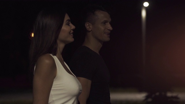 快乐的男人和女人走在夜晚的街上。慢动作视频素材