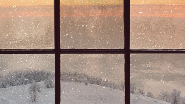 一扇木窗的剪影俯瞰着冬天的黄昏森林。美丽的冬季景观与飘落的雪视频素材