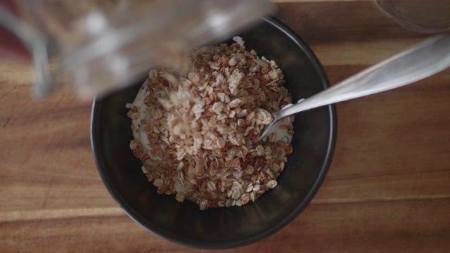 将格兰诺拉麦片和天然酸奶混合在一起作为早餐视频素材