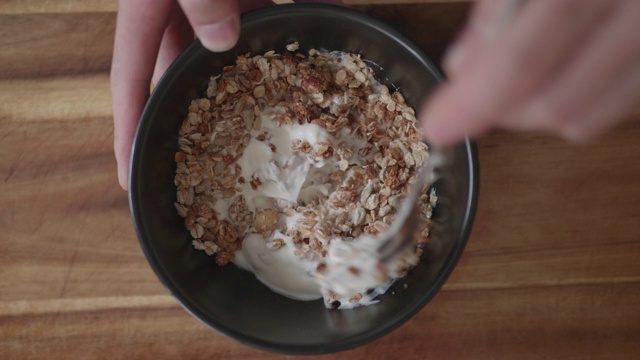 将格兰诺拉麦片和天然酸奶混合在一起作为早餐视频下载