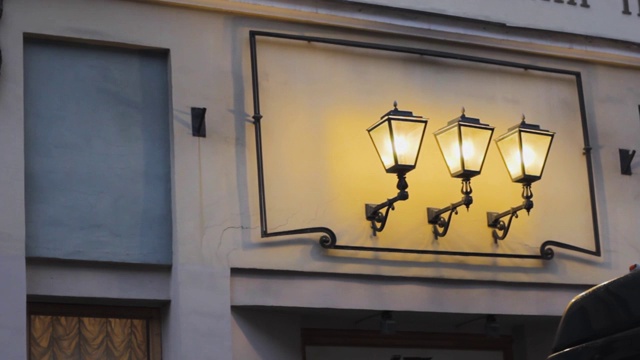 三盏复古经典的装饰灯排成一排。黄色的灯光和阴影。视频素材