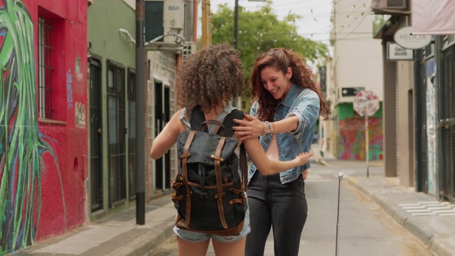 两个旅行中的朋友在城市里相遇并相互拥抱视频下载