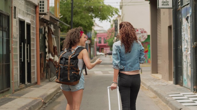 两个旅行的朋友一起走在城市的街道上视频素材