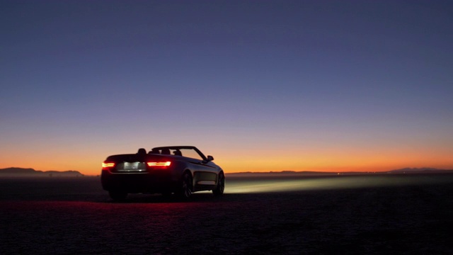 黄昏时分，一个人在加利福尼亚沙漠中开着车，低角度视频下载