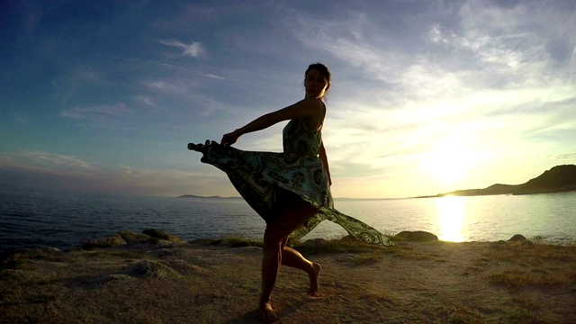 日落时分，在海边跳舞的女人视频素材