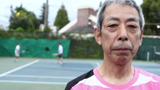 一个严肃的人在网球场上的肖像视频素材