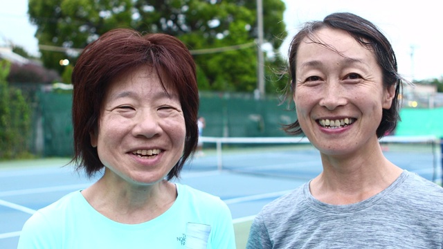 两名女子在网球场上微笑的肖像视频素材