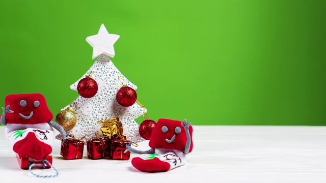 红色的圣诞袜在圣诞树周围拉着礼物，静止不动。圣诞节和新年的概念。视频购买
