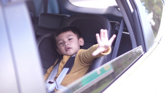 小男孩乘汽车旅行并坐在安全座椅上，4K视频素材
