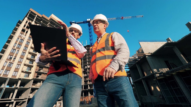 男工程师正在建筑工地操作一台笔记本电脑视频下载
