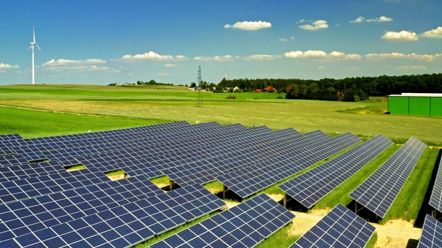 波兰太阳能电池板、风力涡轮机、绿色田野和蓝天的鸟瞰图视频素材