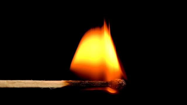 火柴火焰点火和燃烧在黑色背景的慢动作视频素材