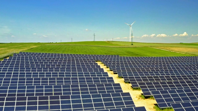 鸟瞰图的太阳能电池板和风力涡轮机在绿色的田野与蓝天，波兰视频素材
