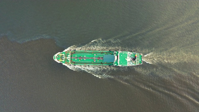 航拍俯视图油船全速与美丽的波浪图案去装货码头装货/卸货在炼油厂。视频下载