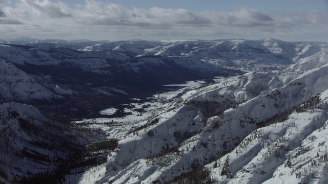 广角的雪景出现在一个多岩石的山腰后面视频素材