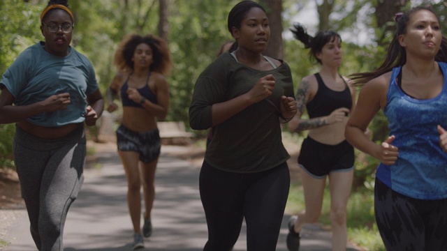 一群女运动员一起在森林里的小路上跑向镜头视频下载
