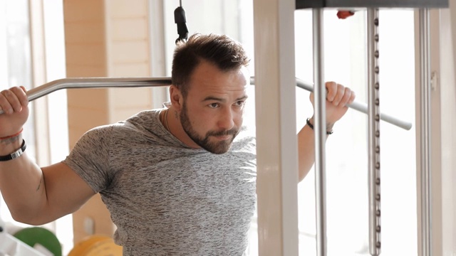 男人在健身房锻炼，使他的肌肉更强壮视频素材