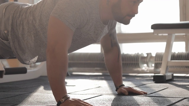 一个男人在健身房做俯卧撑视频素材