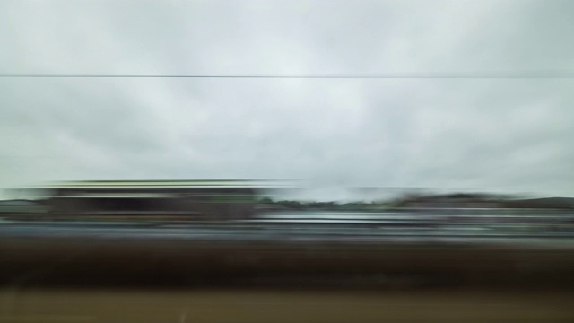一名乘客从快速移动的火车窗口向外看的时间流逝，通过一个英国农村景观与阴霾的天空视频下载