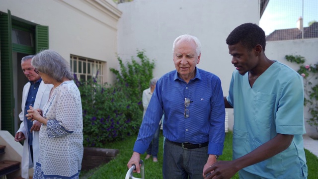 黑人医疗保健工作者帮助老年人在户外行走视频下载