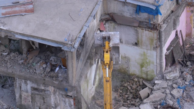 在建筑工地用斗式挖掘机拆除旧房子视频素材