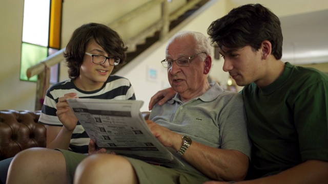 爷爷和孙子们在看报纸视频素材
