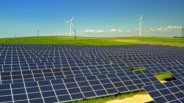 太阳能电池板和风力涡轮机在绿色的田野与蓝天，鸟瞰图，波兰视频素材