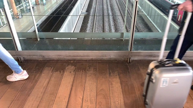 带着行李的人在火车站的人行道上经过视频素材