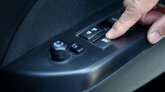 特写的司机的手按下按钮开关电动锁窗户在汽车的安全。技术和交通理念。视频素材