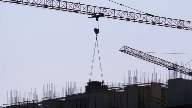 建筑工地上的塔式起重机在高层建筑中吊装重物。间隔拍摄视频素材