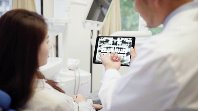 牙医给病人看牙齿x光片视频素材