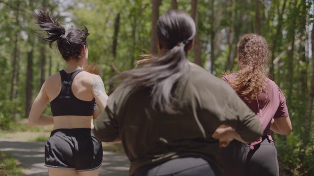 一群女运动员一起在森林里的一条小路上奔跑视频下载
