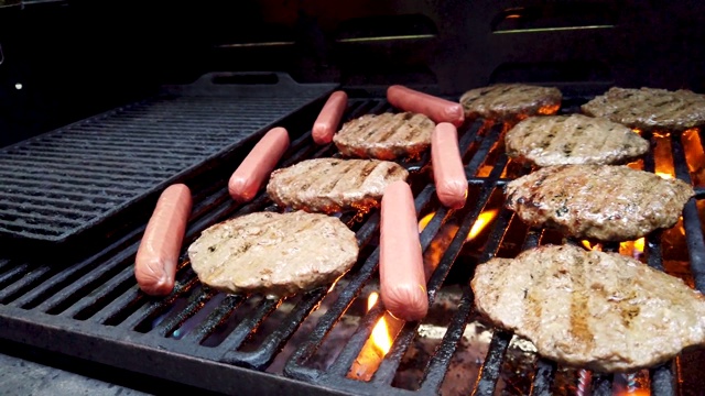 将生热狗和汉堡放在热烤架上，低角度，近距离拍摄。视频素材
