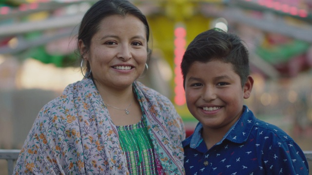 一个快乐的西班牙母亲和儿子在夏季嘉年华的肖像视频下载