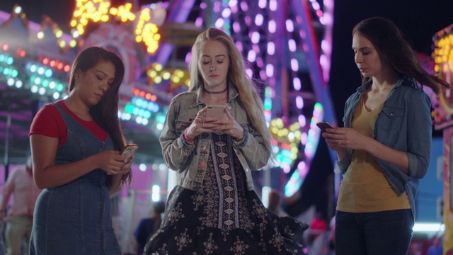三个千禧一代的友敌无视彼此，在狂欢节上玩手机视频下载