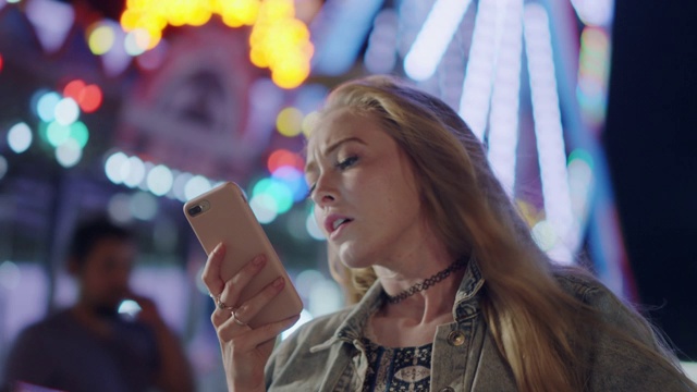 一个势利的千禧女在晚上的狂欢节上用手机视频素材