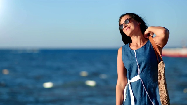 放松的黑发旅行女人享受在假期的日落漫步在海滩上视频下载