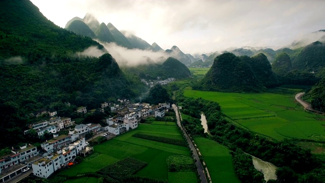 鸟瞰喀斯特山峰森林(万峰林)中的村庄和稻田，贵州，中国。视频素材