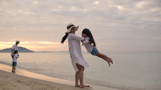 母亲在海滩上纺纱女儿。缓慢的运动。视频素材