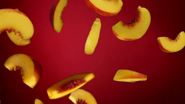 桃片在红色的背景上飞落下来视频素材