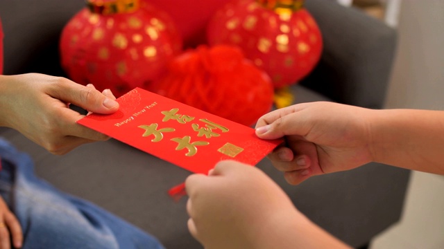 快乐的亚洲妇女在春节庆祝活动中给孩子红包视频下载