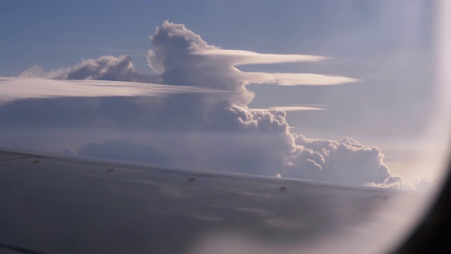 从一架在机翼上的客机的窗口观看和天空中的云视频下载