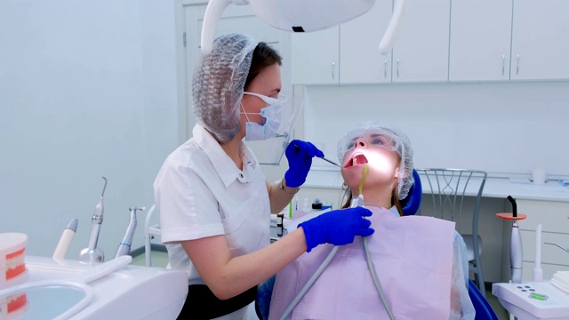 牙科医生在口腔诊所治疗年轻女子的牙齿，治疗过程。视频素材