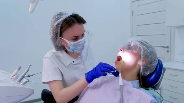 牙科医生在诊所用餐巾擦拭女病人的脸进行超声波清洗。视频素材