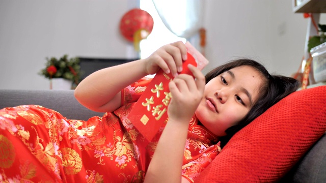 慢镜头，快乐的亚洲女孩拿着春节庆祝活动的红包视频下载