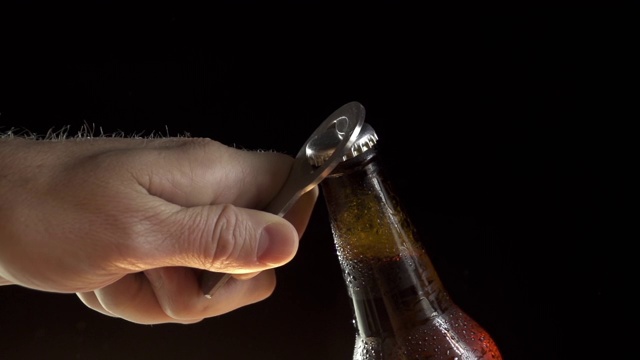 一只手打开一瓶啤酒的特写慢动作视频素材