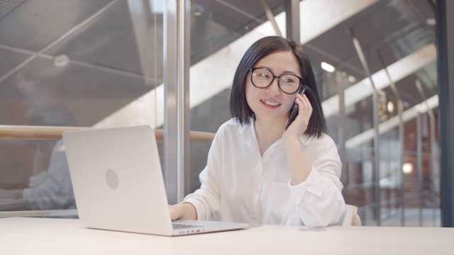 漂亮的亚洲女人在工作场所打电话视频素材